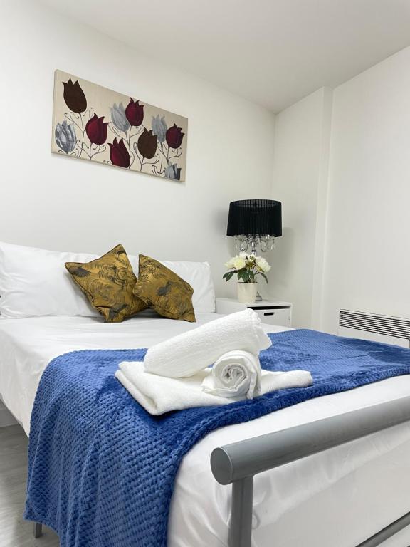 een slaapkamer met een bed met handdoeken erop bij Wharf Inn Premier Apartment Central Manchester - Free Private Parking in Manchester