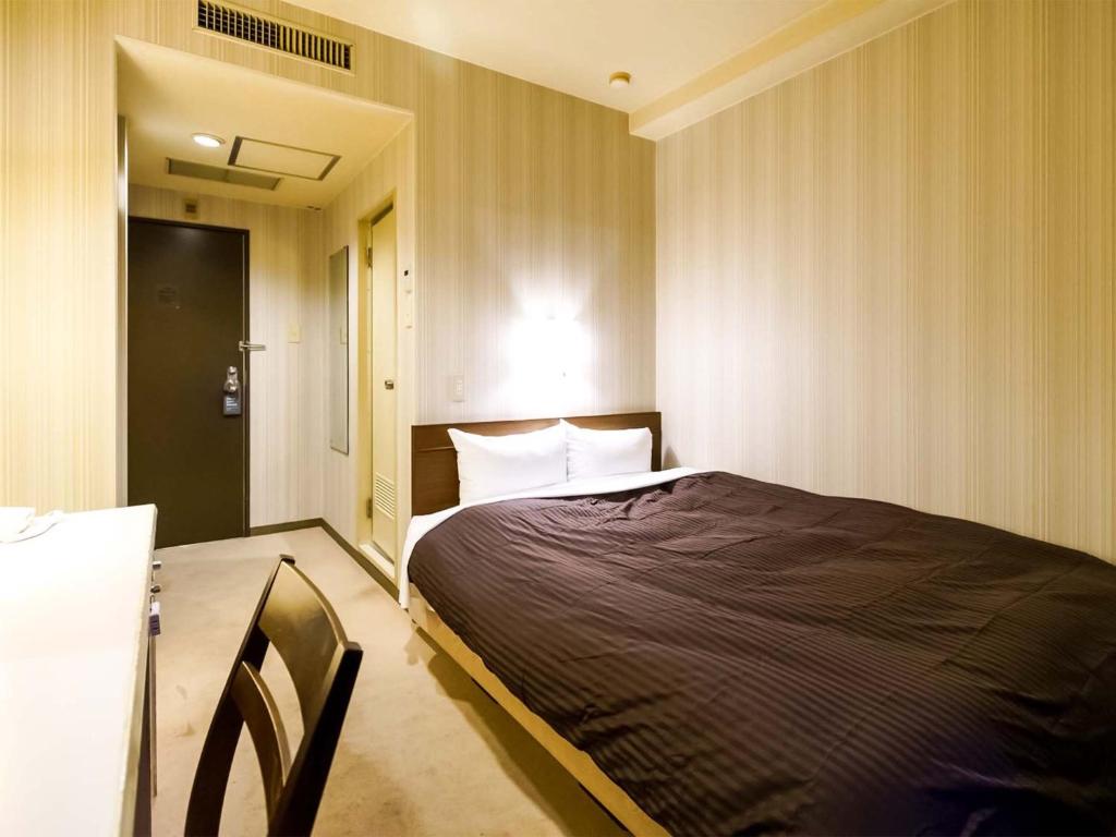 a bedroom with a bed and a table and a chair at City Hotel Air Port in Prince - Vacation STAY 80789v in Izumi-Sano