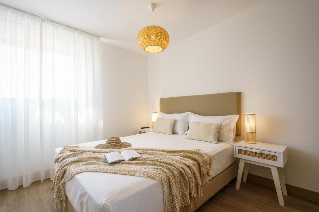 een slaapkamer met een groot bed met een boek erop bij Villa Ria by Aqualeisure in Ovar