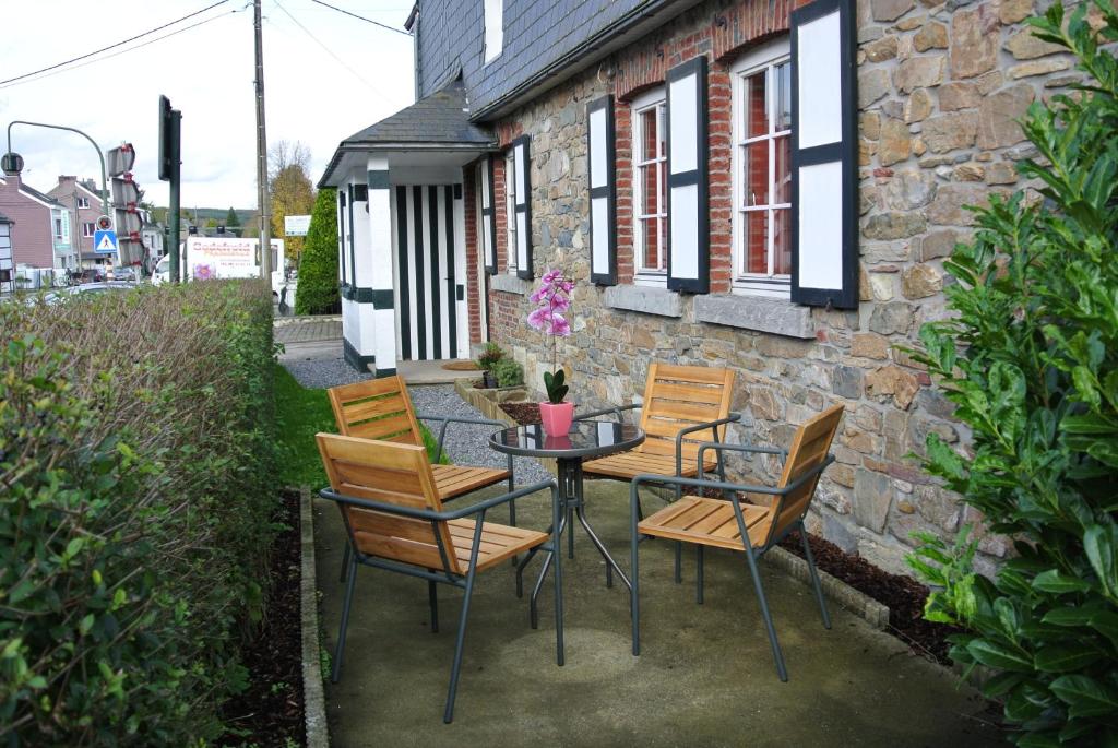 un patio con mesa y sillas frente a un edificio en La Doyenne, en Francorchamps