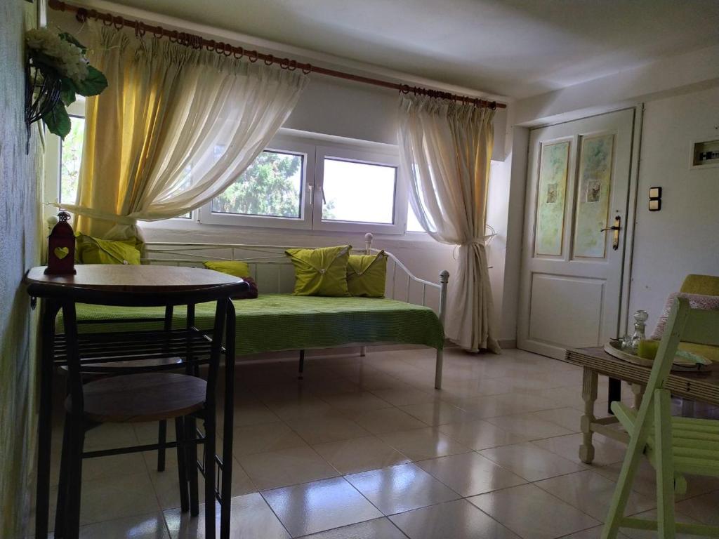 een woonkamer met een groene bank en een raam bij Agni apartment - Sunset in Blue in Ierápetra