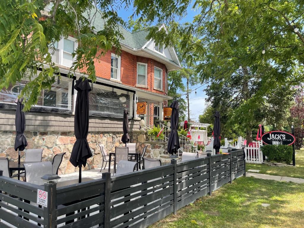 a fence with chairs and umbrellas in front of a building at Inn 31 in Kingsville