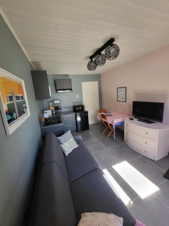 a living room with a couch and a kitchen at Logement proche de Bordeaux, route des Châteaux in Ludon-Médoc