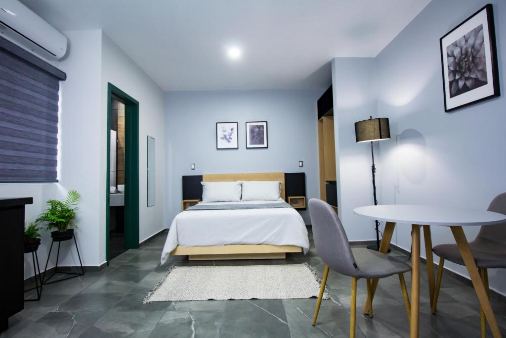 a bedroom with a bed and a table and chairs at Nidah Condominios in Durango