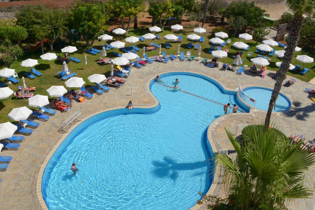 een uitzicht over een zwembad met parasols en stoelen bij Artemis Hotel Apartments in Protaras