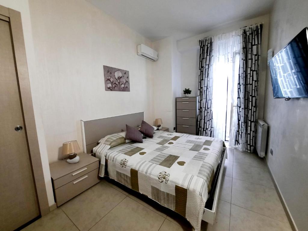Un dormitorio con una cama grande y una ventana en Campi Elisi, en Siracusa