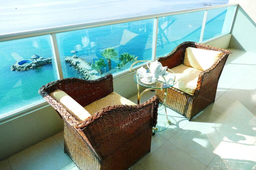 two chairs and a table on a balcony with the ocean at Ecusuites Playa Privada Piscina Jacuzzi 7B- a 10 min Salinas in Salinas