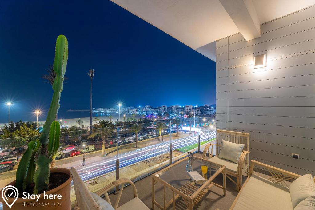 a balcony with a view of a city at night at Stayhere Agadir - Ocean View Residence in Agadir