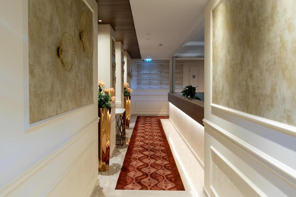 a corridor with a red carpet in a hallway at Leonardo Boutique Hotel Larnaca in Larnaca