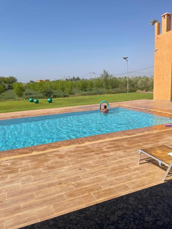uma pessoa a nadar numa piscina em Villa atlas farm strictement pour les familles em Marrakech