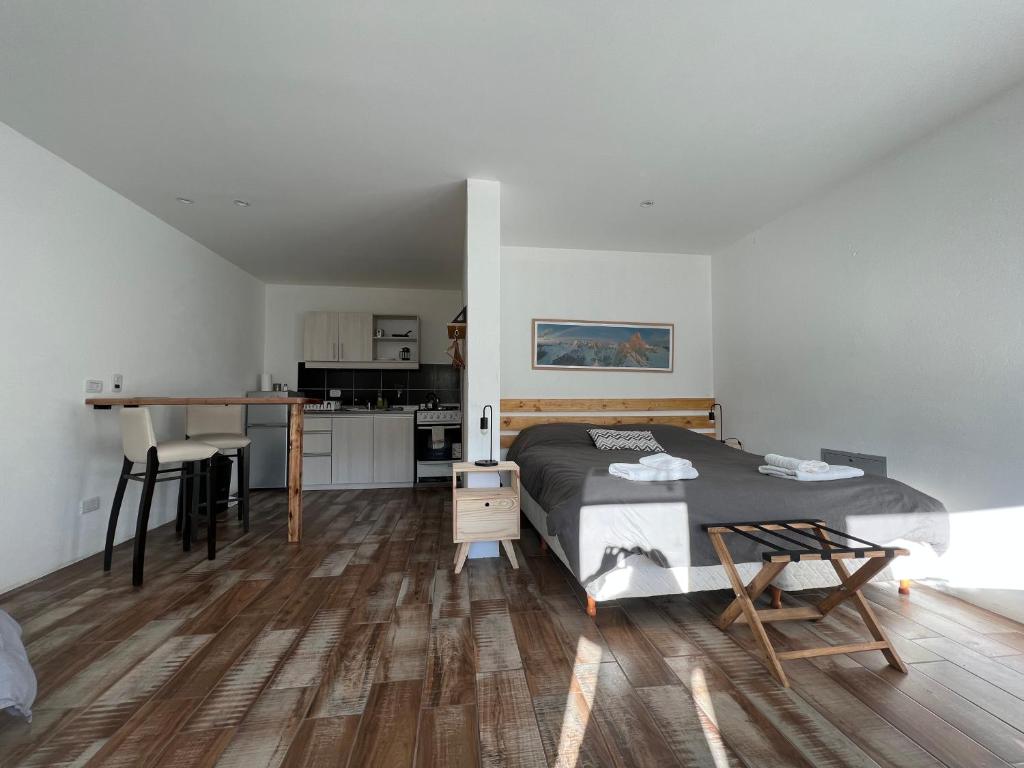 a bedroom with a bed and a desk and a kitchen at Chalten Mountain Lofts 4 in El Chalten