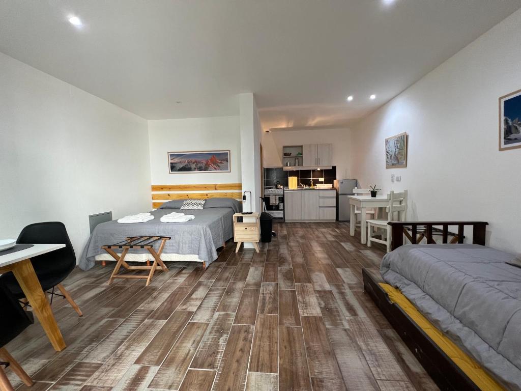 Cet appartement comprend une chambre avec deux lits, une table et une cuisine. dans l'établissement Chalten Mountain Lofts 7, à El Chalten
