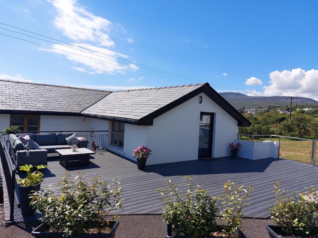 a house with a large deck in front of it at Mulranny Bay Apartment in Mulranny