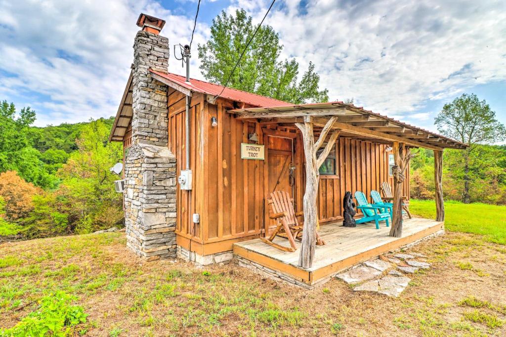 a wooden cabin with a porch and chairs in a field at Mountian View Retreat Less Than 2 Mi to White River! in Mountain View