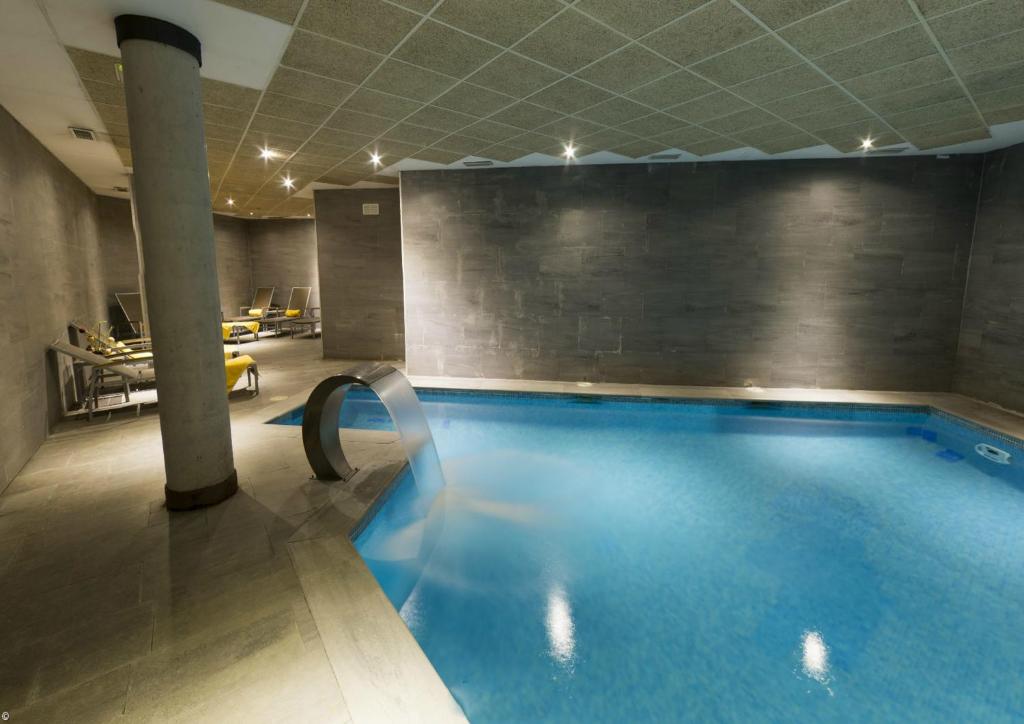 duży basen w budynku z basenem w obiekcie Hotel Isla de La Garena w mieście Alcalá de Henares
