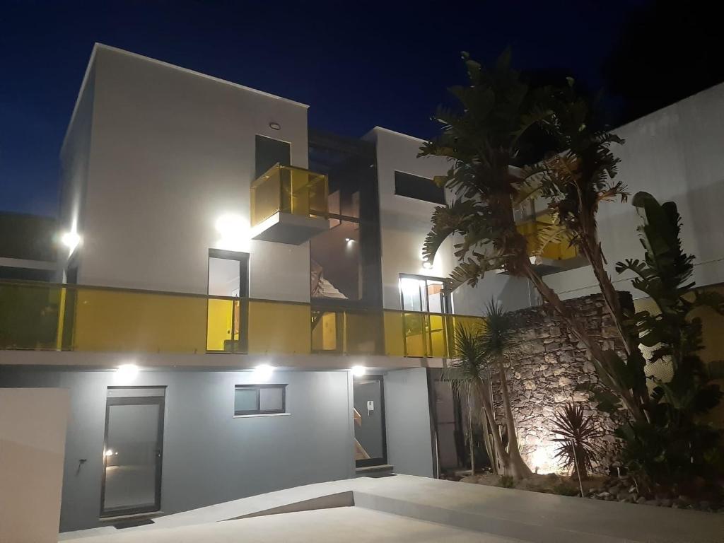 a large white building with yellow accents at night at Amateur Runners in Água de Alto