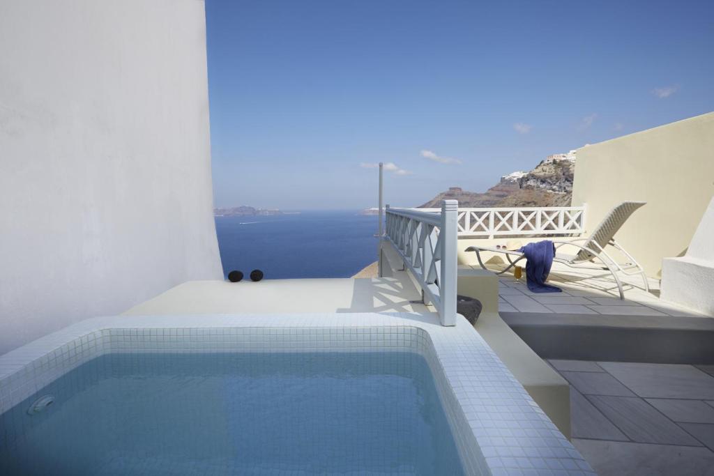 a swimming pool on the balcony of a house at Cori Rigas Suites in Fira