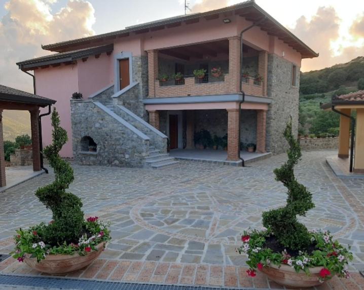 una casa con dos macetas delante de ella en Tenuta il Giardino di Eros, en Albanella