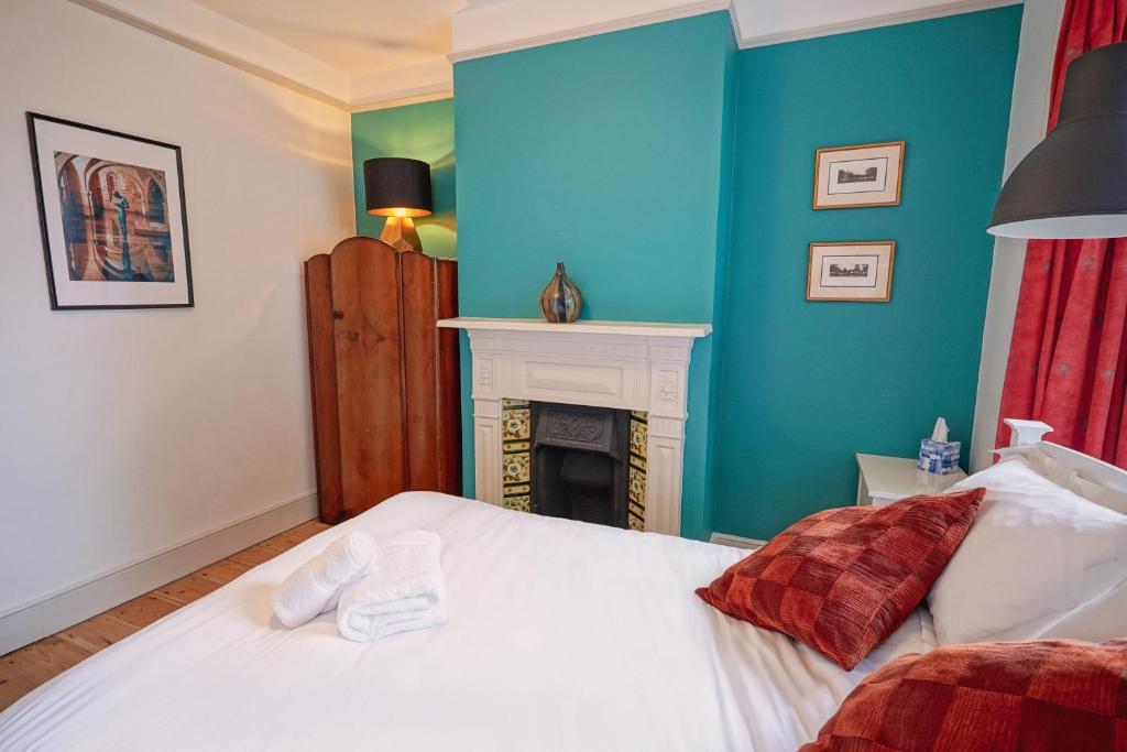 a bedroom with a white bed and a fireplace at Boscobel Apartments Down in Winchester