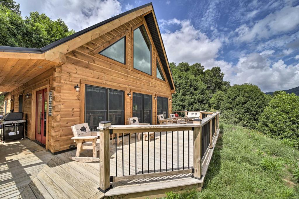 a log cabin with a deck and a grill at Luxe Log Cabin with Modern Finishes and Mtn Views in Maggie Valley