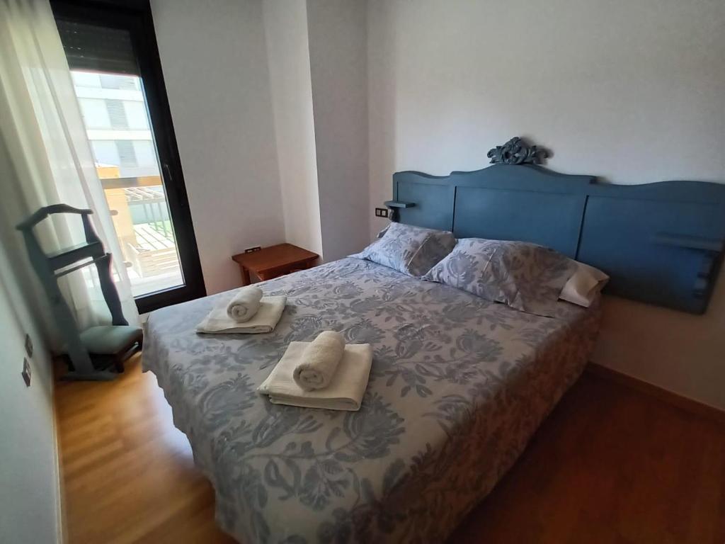 een slaapkamer met een blauw bed en handdoeken bij LUCIA S HOUSE in Mairena del Aljarafe