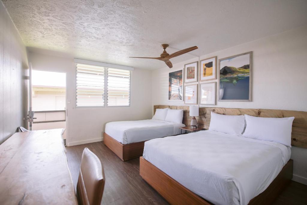 SCP Hilo Hotel في هيلو: غرفة نوم بسريرين ومروحة سقف