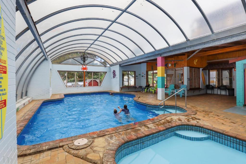 a pool with two people in the water at Anchor Belle Holiday Park in Cowes