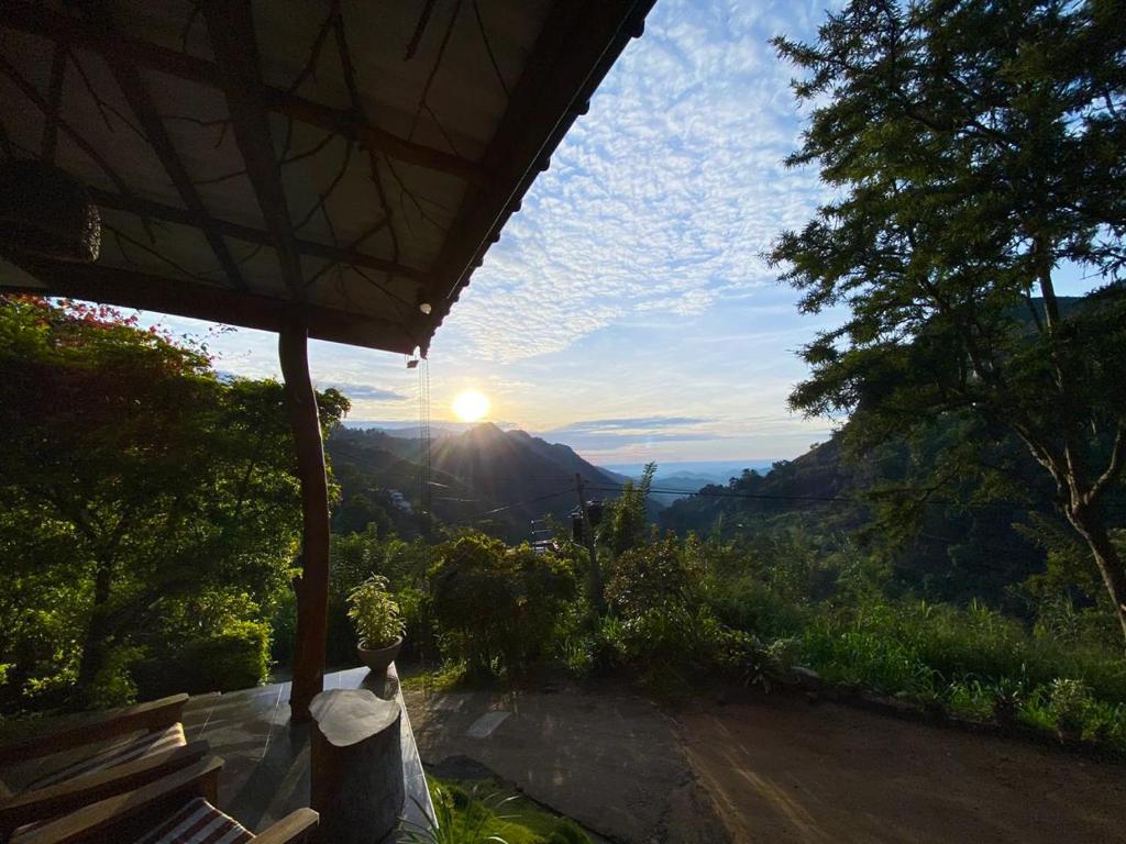 a person sitting on a bench watching the sunset at Leisure Dream Inn in Ella