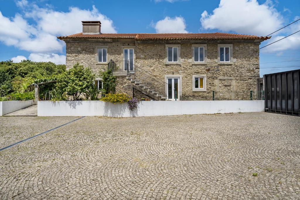 une grande maison en pierre avec une allée en pierre dans l'établissement Nomad's Country - 4BED Casa de Macieira, à Santa Maria da Feira