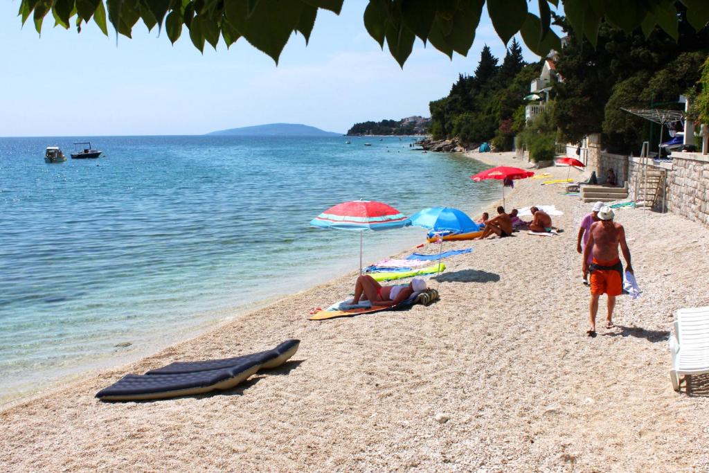 a group of people on a beach with umbrellas at Apartments with a parking space Podaca, Makarska - 4747 in Podaca