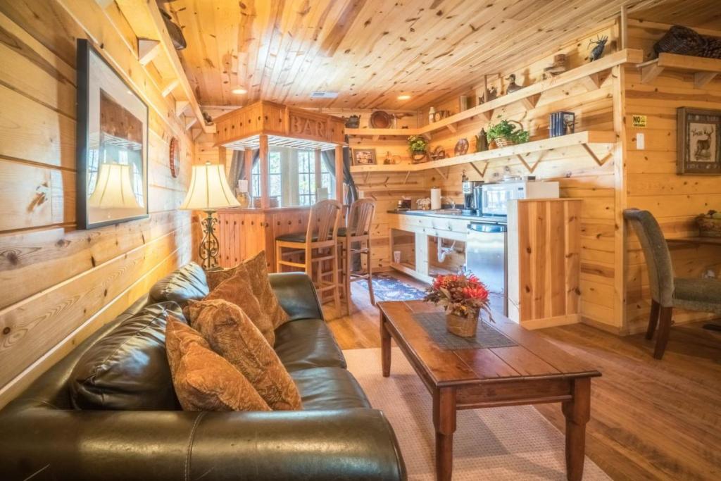 a living room with a leather couch and a table at Nacoochee valley motel in Clarkesville