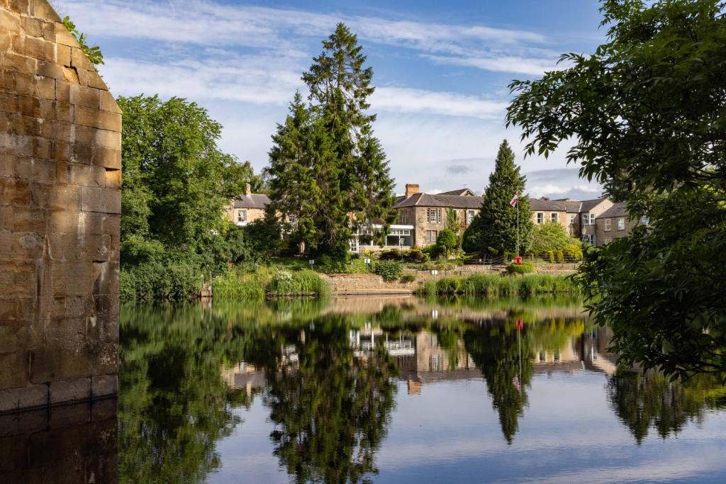 uma vista para um rio com casas e árvores em George Hotel em Hexham