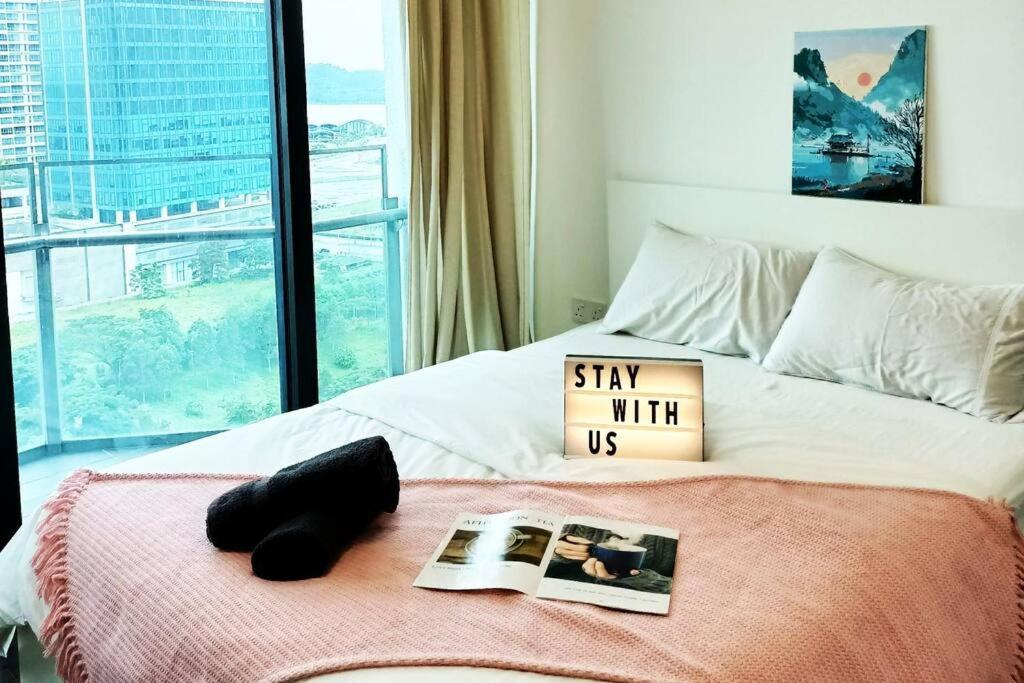 een slaapkamer met een bed met een boek en een tijdschrift bij C0503 Almas suites NETFLIX!100mbps BySTAY in Nusajaya