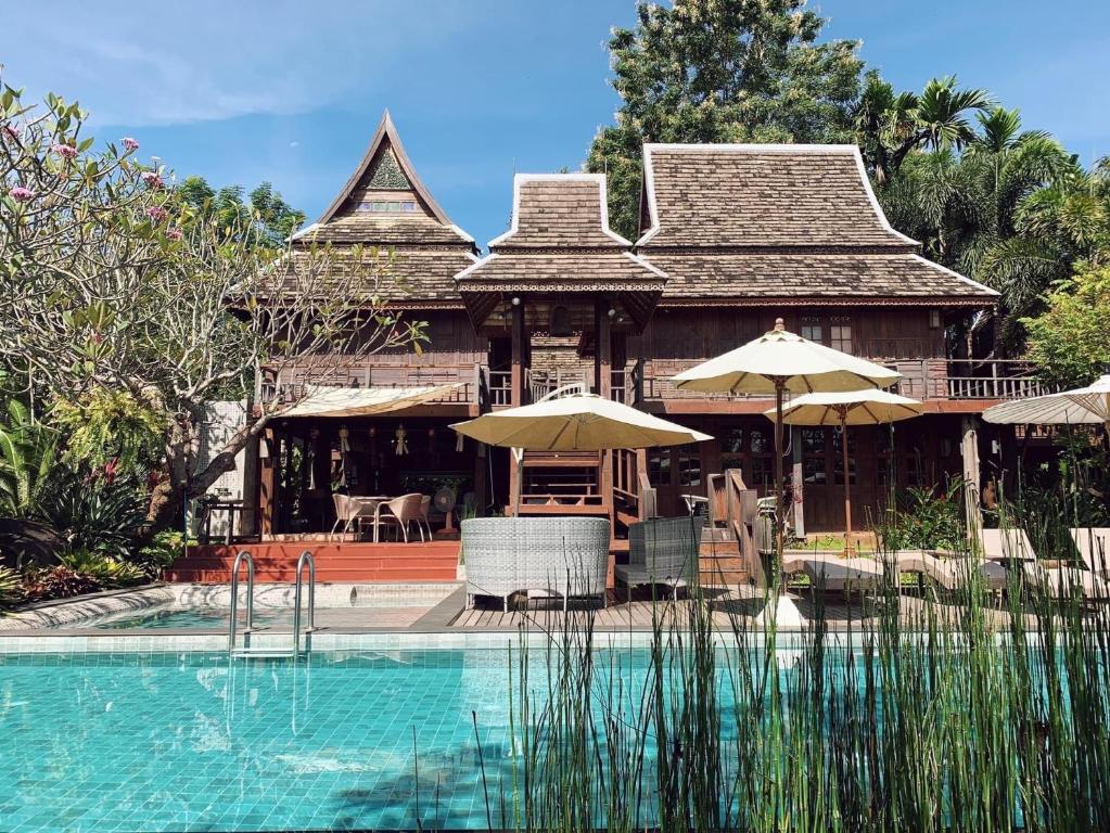 una casa con piscina frente a una casa en Baansuwanburi en Chiang Mai