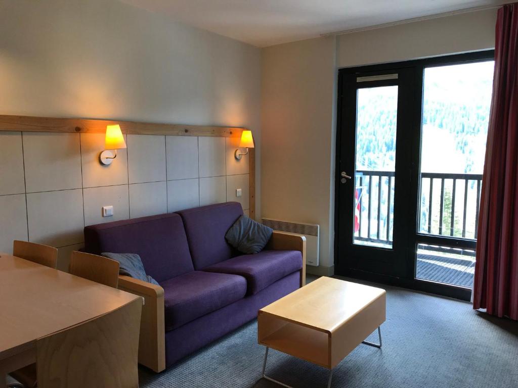 ein Wohnzimmer mit einem lila Sofa und einem Tisch in der Unterkunft Appartement Flaine, 2 pièces, 5 personnes - FR-1-425-175 in Arâches-la-Frasse