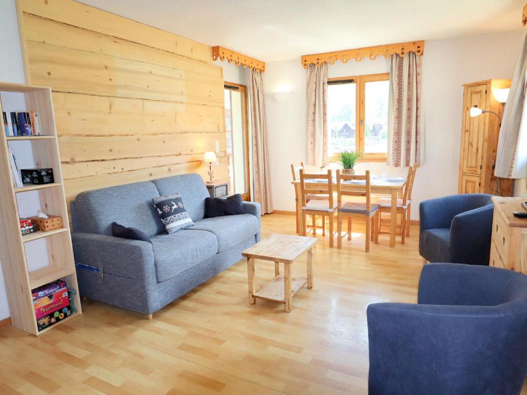a living room with a blue couch and a table at Appartement Samoëns, 2 pièces, 6 personnes - FR-1-624-117 in Samoëns
