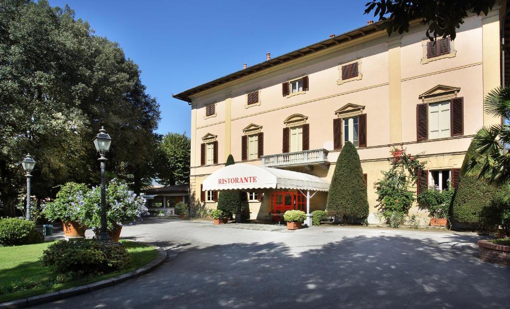 un grande edificio con un cartello di Aania sulla parte anteriore di Hotel Villa Delle Rose a Pescia