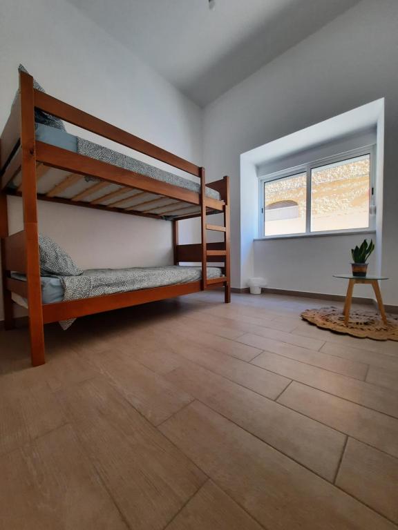 a room with two bunk beds and a wooden floor at Blue Sardine Hostel in Portimão