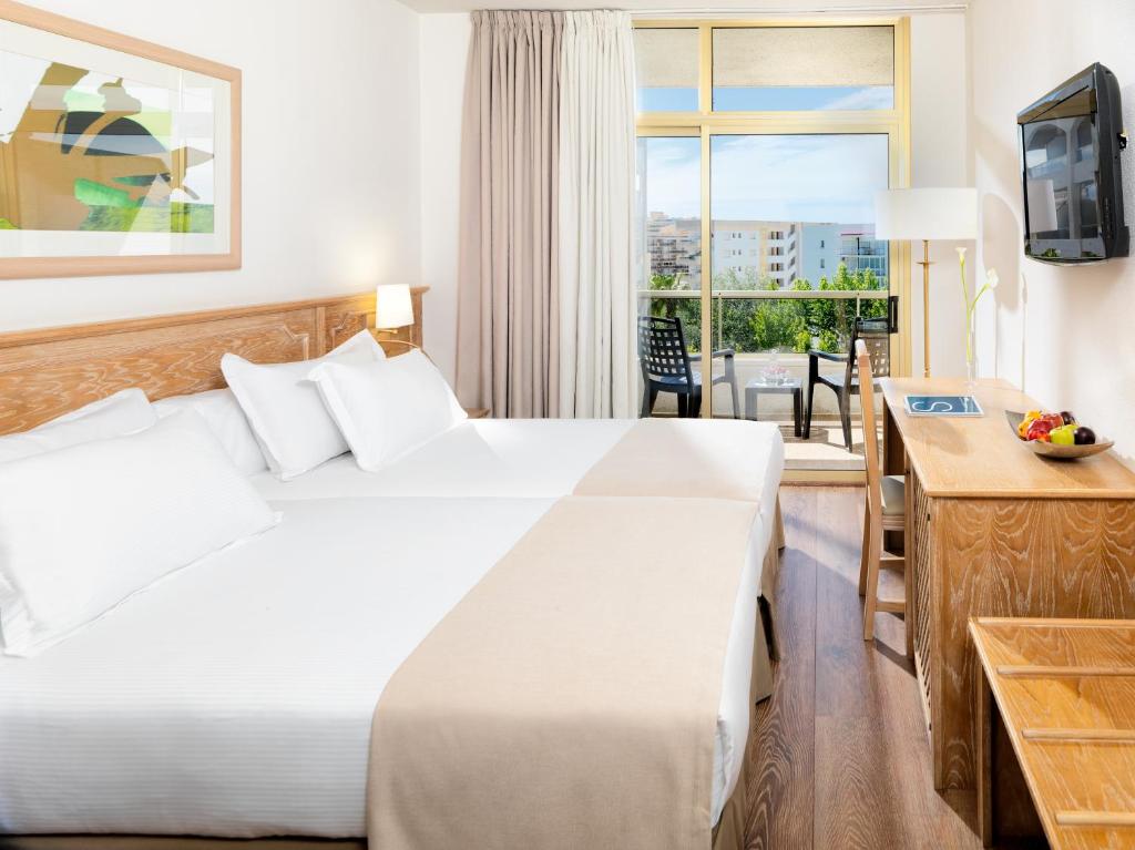 Una habitación de hotel con una cama y una ventana. en H10 Salou Princess, en Salou