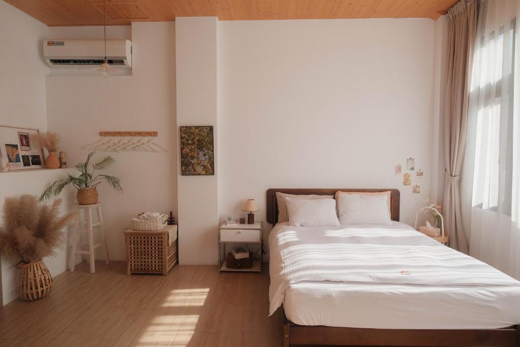 a bedroom with a white bed and a window at Privacy Home in Tainan