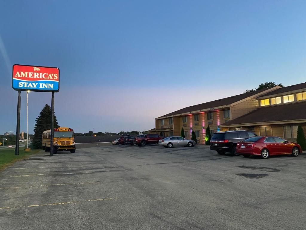 un cartello per un hotel americano in un parcheggio di America's Stay Inn Stewartville a Stewartville