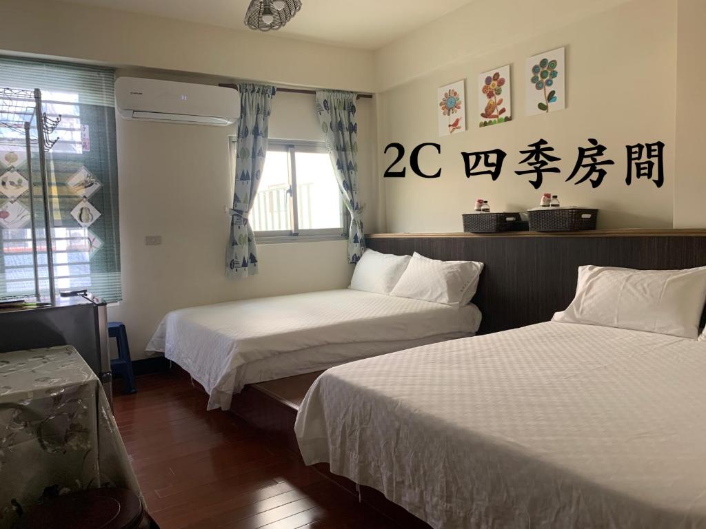 富里穀鄉民宿的有两张床和一扇窗户的酒店房间