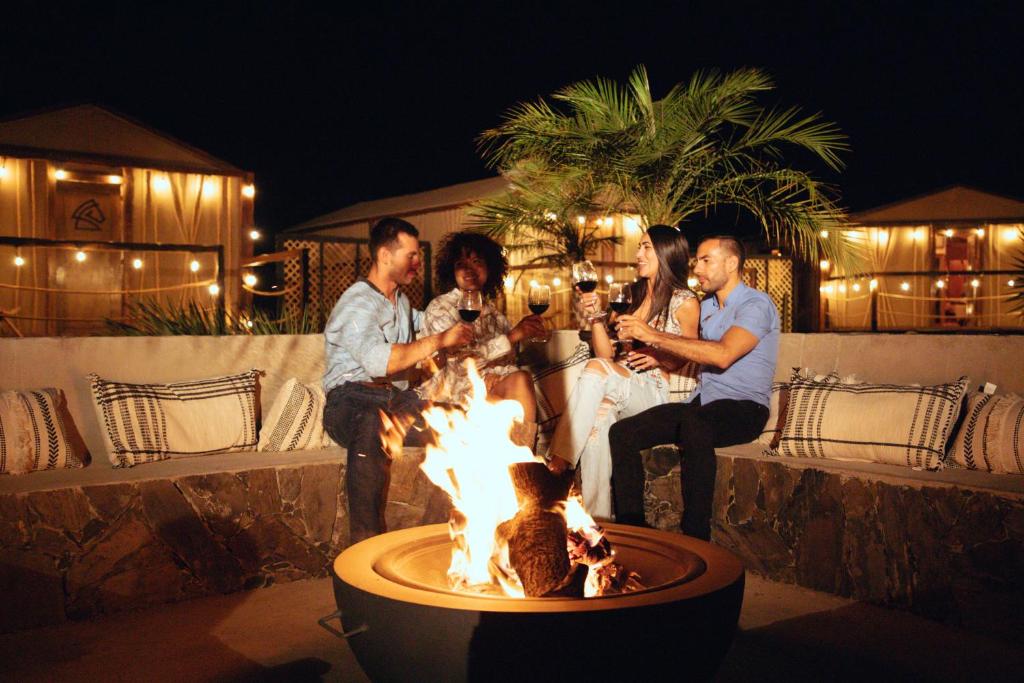 a group of people sitting around a fire pit at Indomito Resort & Hotel Boutique in Valle de Guadalupe