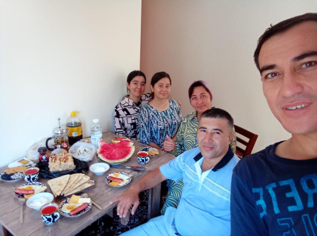 a group of people sitting around a table with food at Ancient Khiva in Khiva