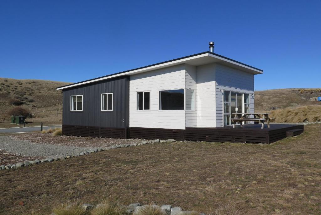 een zwart-wit tiny house op een heuvel bij Ashley Heights in Lake Tekapo