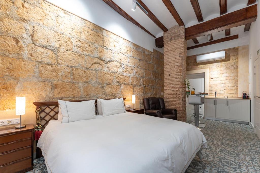 a bedroom with a large bed and a brick wall at Tosca 2 PAX by costablancarent in Denia