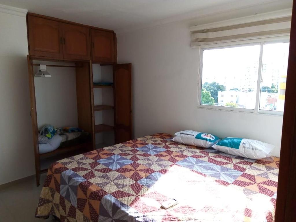 - une chambre avec un lit doté d'une couette dans l'établissement Bonito apartamento en Cartagena con garaje gratuito, à Carthagène des Indes