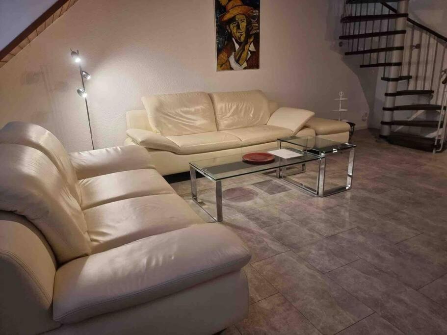 uma sala de estar com um sofá e uma mesa em Apartment near Bonn/Cologne with nature access em Troisdorf