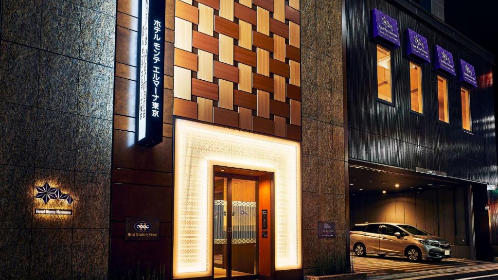 a building with a car parked outside of it at Hotel Monte Hermana Tokyo in Tokyo