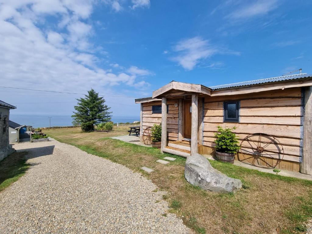 a log cabin with a gravel path next to it at Byre Cottages & Log Cabin in Cardigan